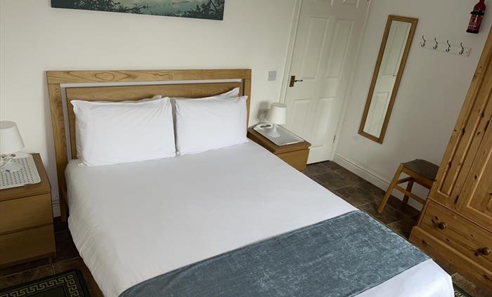 Shows positioning of pine wardrobe, king size bed, mirror, table lamps, and 2 bedside cabinets.
